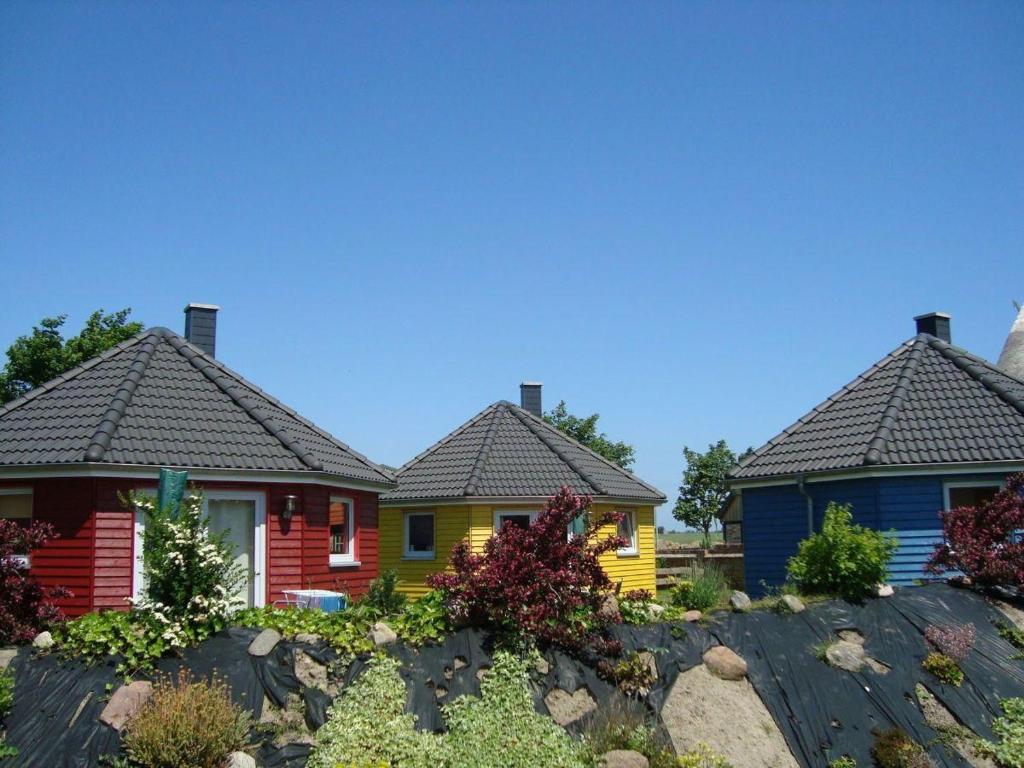 een rij kleurrijke huizen met daken bij Bungalow-Gelb-Peters in Börgerende-Rethwisch