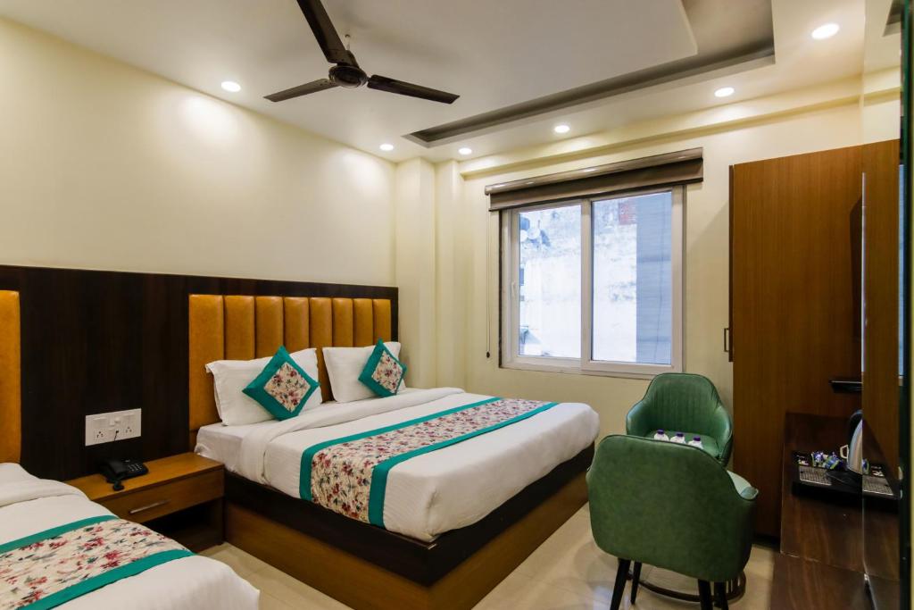 una habitación de hotel con 2 camas y una silla en Hotel Royal Rosette Unit By Silver Shine, en Nueva Delhi