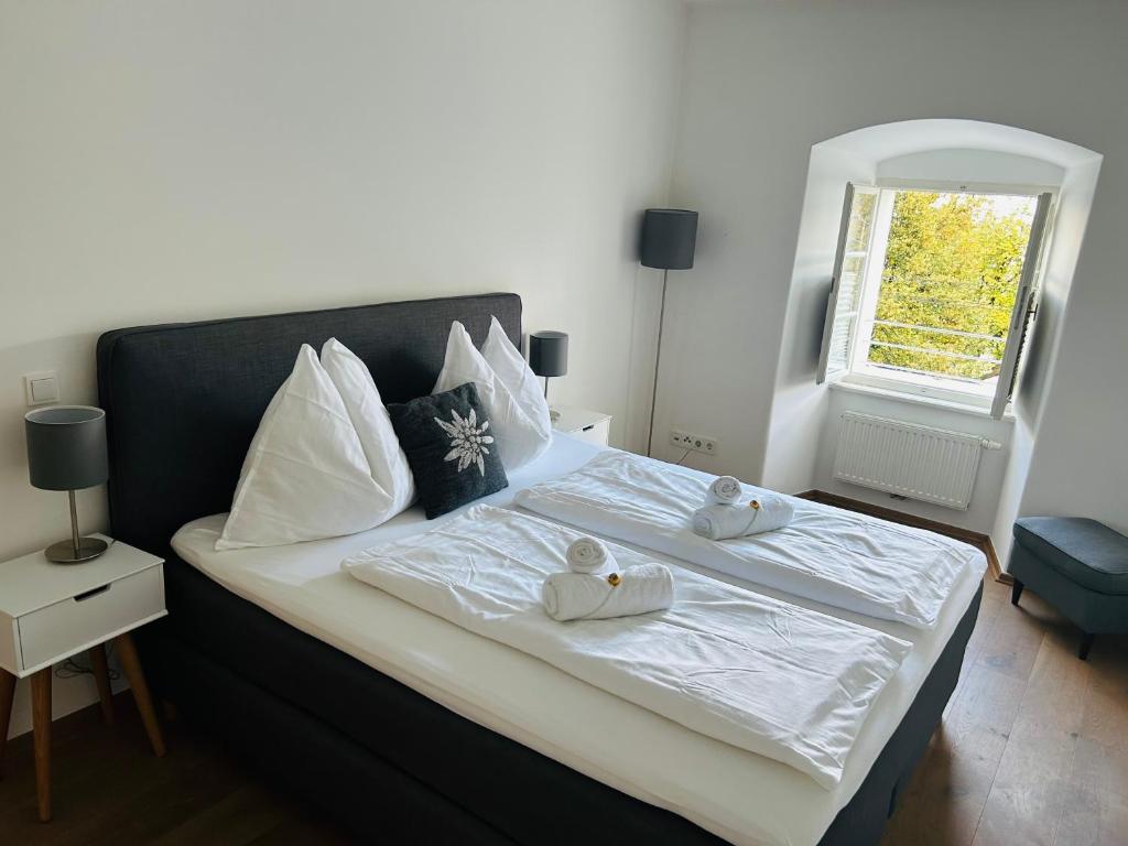1 dormitorio con 1 cama con 2 toallas en Palais am Kai - Zentrale Lage, Kostenloser Parkplatz, en Salzburgo