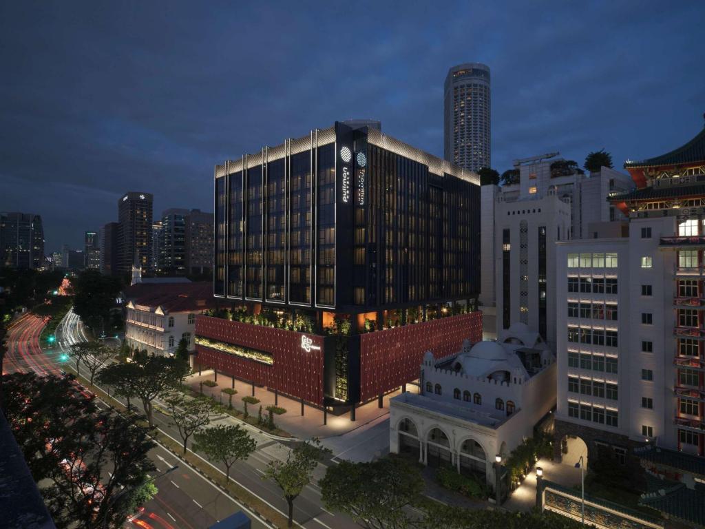 Pullman Singapore Hill Street في سنغافورة: مبنى كبير في مدينة في الليل