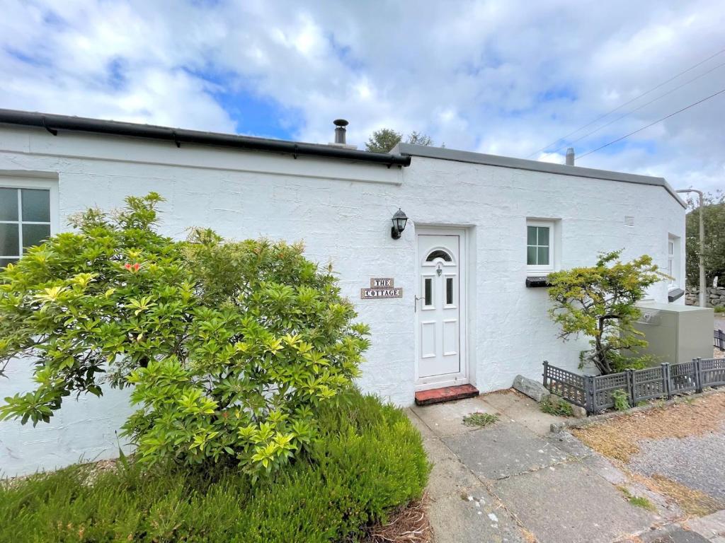 una casa di mattoni bianchi con una porta bianca di Pass the Keys Traditional Scottish Cottage in Beautiful Location a Rockcliffe