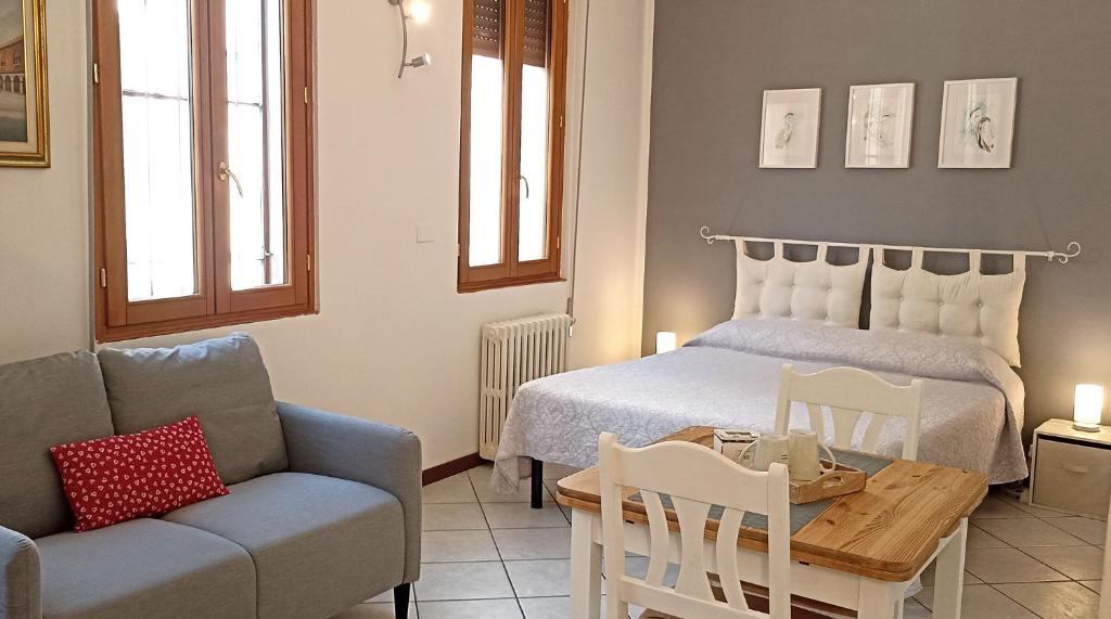 a bedroom with a bed and a couch and a table at Cecily's House in Mantova