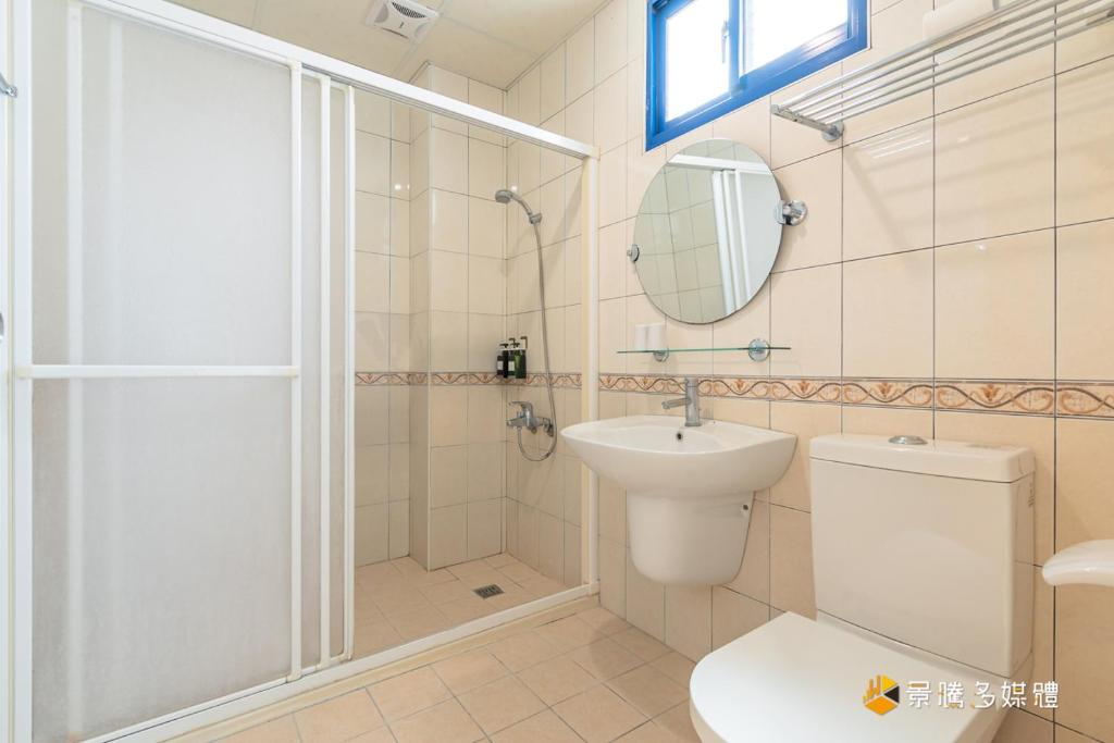 a bathroom with a shower and a toilet and a sink at Promised Land B&amp;B in Taitung City