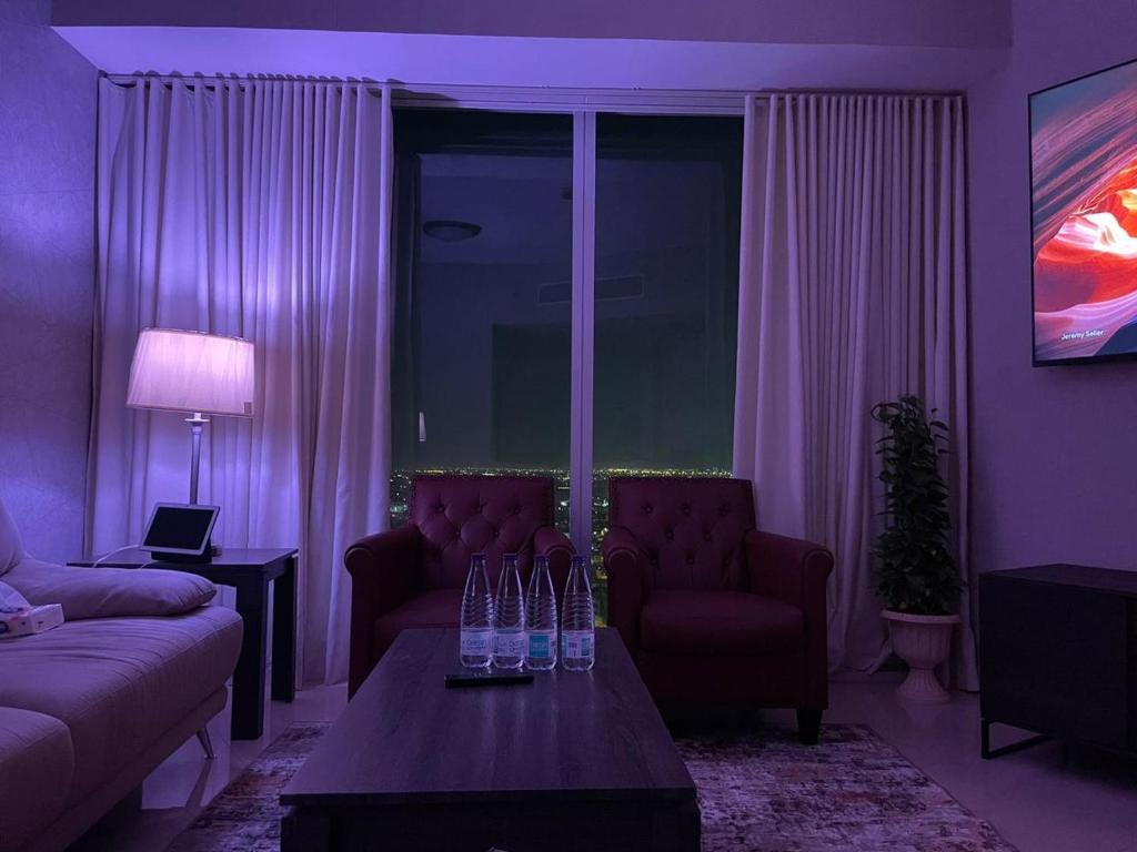 uma sala de estar roxa com um sofá e uma mesa em Cozy Suite with Sky view em Riyadh