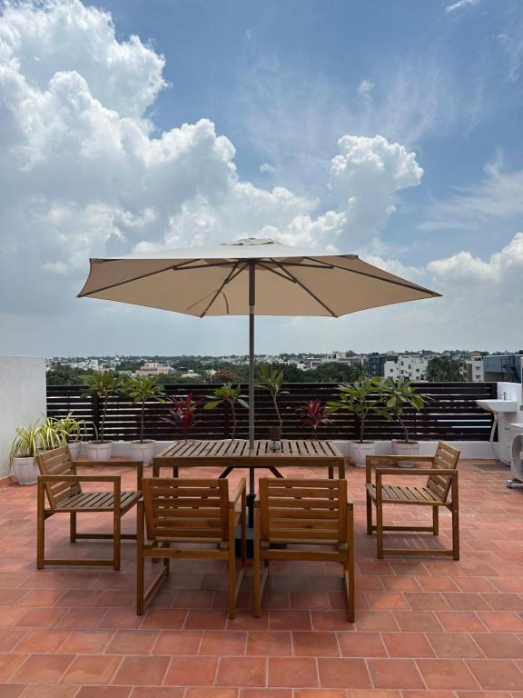 a table and chairs with an umbrella on a roof at Hut in the sky in Bangalore