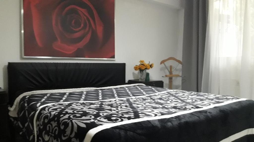 Una cama en blanco y negro en un dormitorio con una pintura en Erato, en Atenas