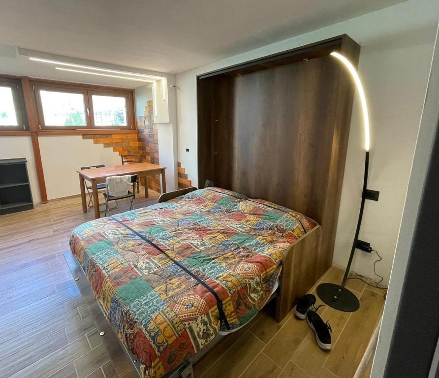 Un dormitorio con una cama y una mesa con una mesa. en Bilocale Funivie, en Breuil-Cervinia