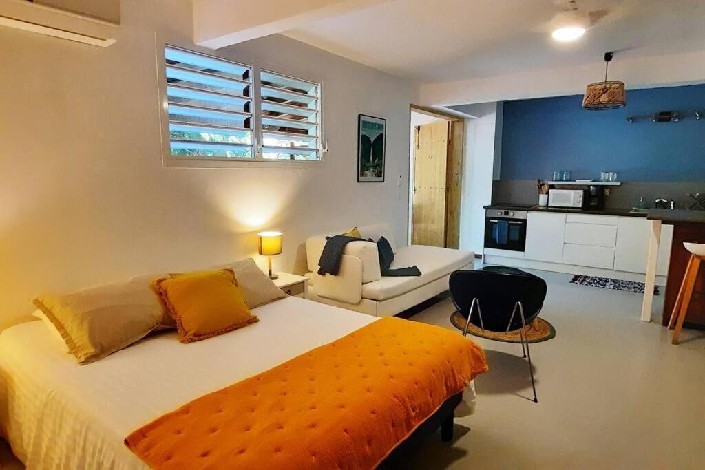 um quarto com uma cama grande e uma cozinha em Studio à la campagne, L'Aqua verde em Le Gosier