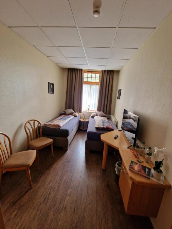 a living room with a couch and a table at Gasthaus Pension DÖRENKRUG - Restaurant in Augustdorf