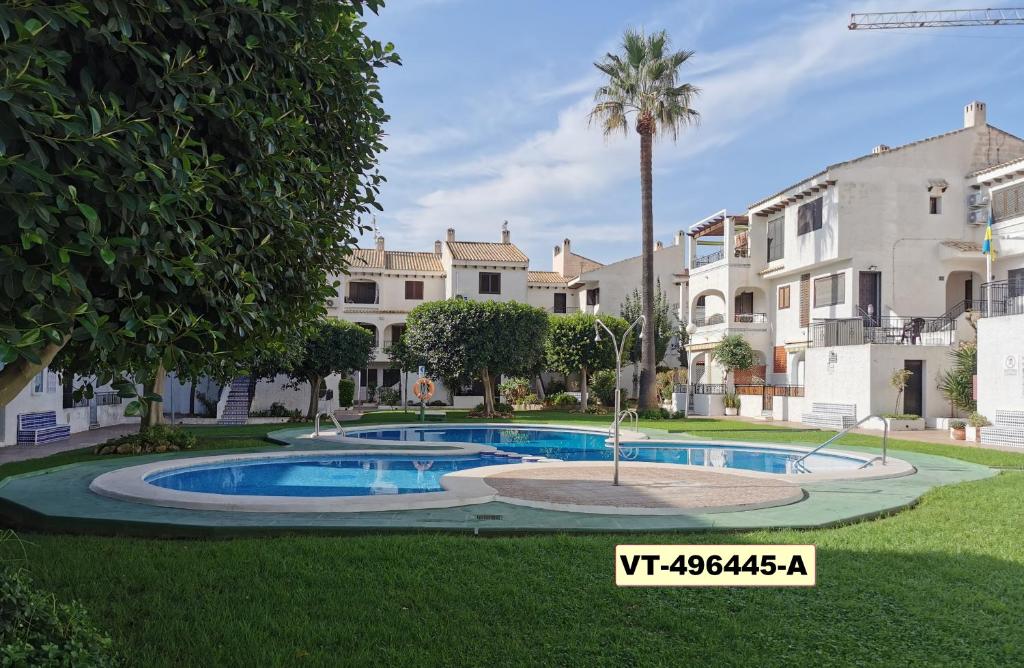 uma piscina no meio de um quintal com casas em Oleza Garden Village , Apartment Ines em Playa Flamenca