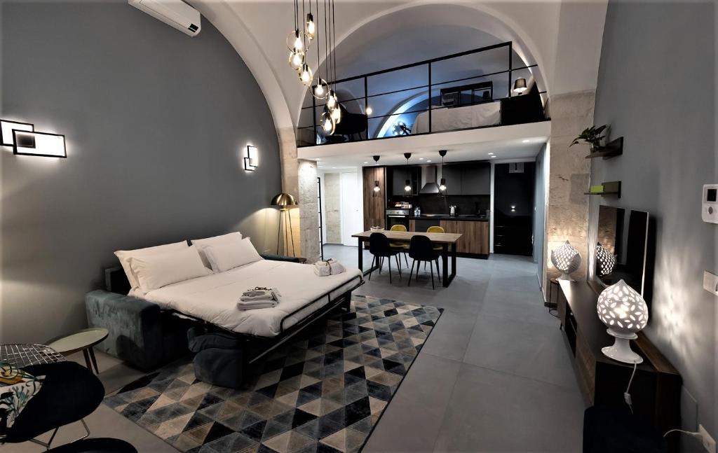 uma sala de estar com um sofá e uma sala de jantar em San Giacomo Loft Apartment em Barletta