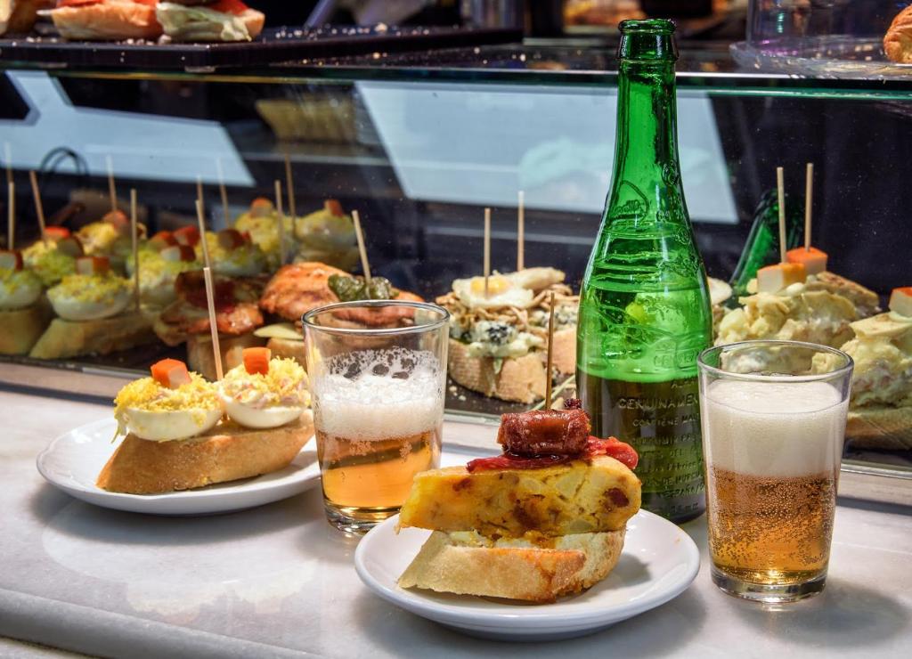 a table with plates of food and two glasses of drinks at Spacious Confortable Next Beach and Pintxos Area in Donostia-San Sebastián