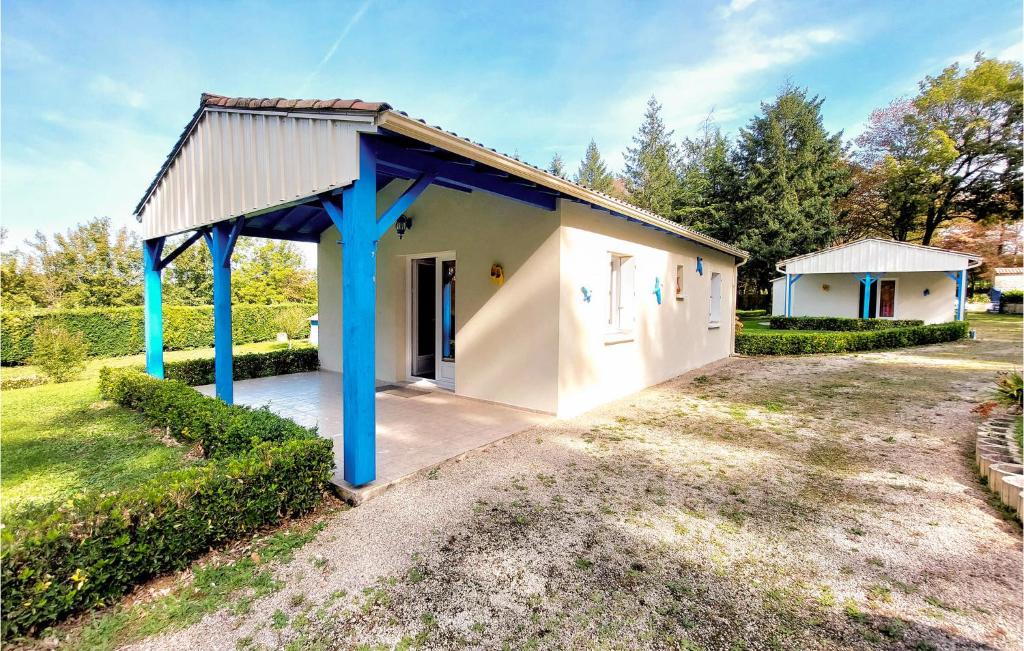 un petit bâtiment blanc avec des poteaux bleus dans une cour dans l'établissement 2 Bedroom Nice Home In Souvigne, à Souvigné