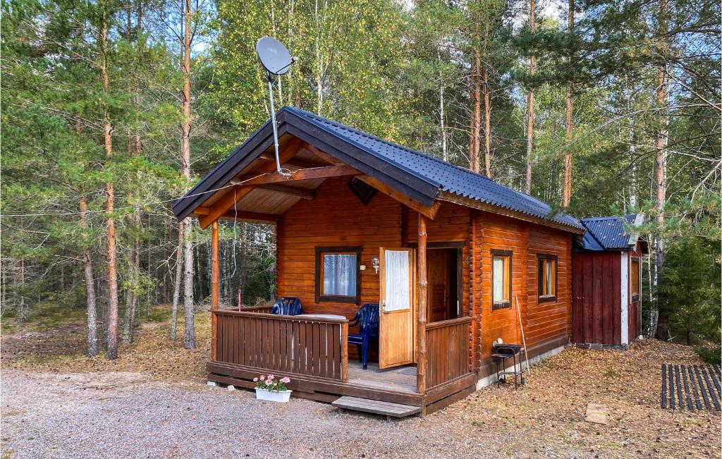 a wooden cabin in the woods with a porch at Stuga 4 in Nybro