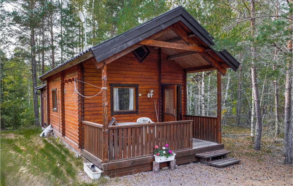 een houten hut in het bos met een veranda bij Stuga 2 in Nybro