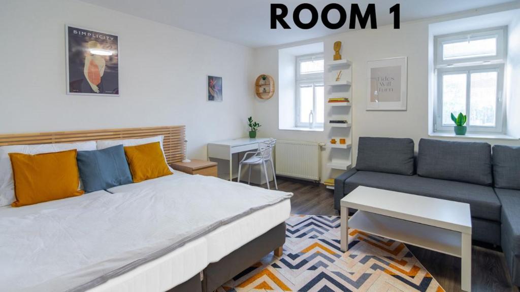 a bedroom with a bed and a couch and a table at Bookhouse apartment by Prague Castle in Prague