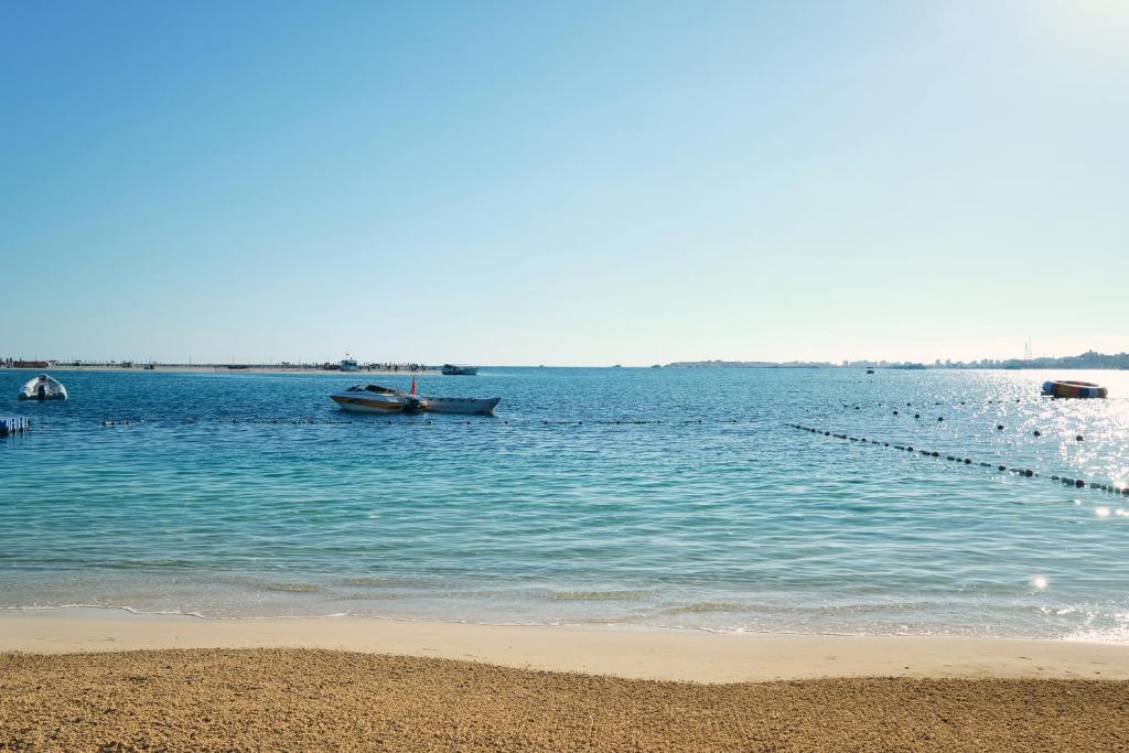 grupa łodzi w wodzie na plaży w obiekcie Triumph White Sands Hotel w mieście Marsa Matruh