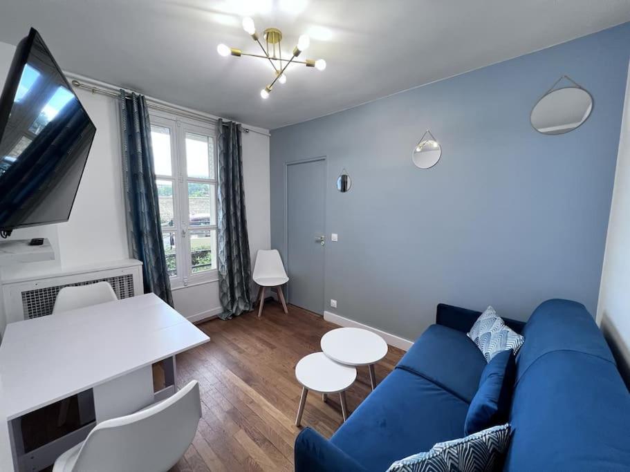 ein Wohnzimmer mit einem blauen Sofa und einem TV in der Unterkunft 4P - 1BR - Boulogne Paris Parc des Princes in Boulogne-Billancourt