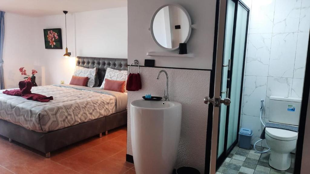 1 dormitorio con cama, lavabo y espejo en Happy Beach Jomtien Guesthouse, en Jomtien Beach