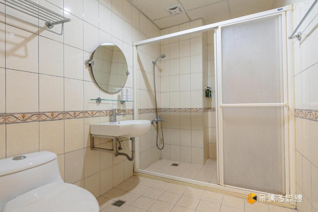 a bathroom with a shower and a toilet and a sink at Promised Land B&amp;B in Taitung City