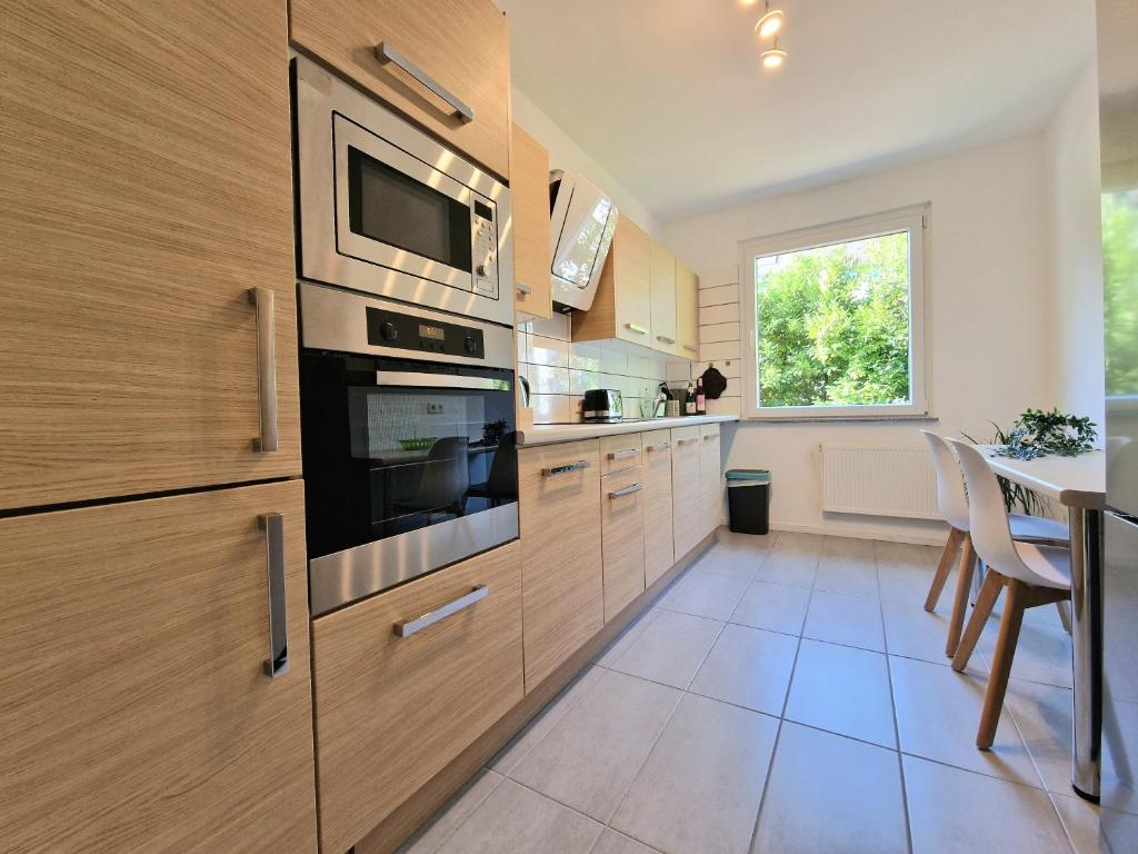 a kitchen with wooden cabinets and a table and a window at Helbings Apartments Essen in Essen