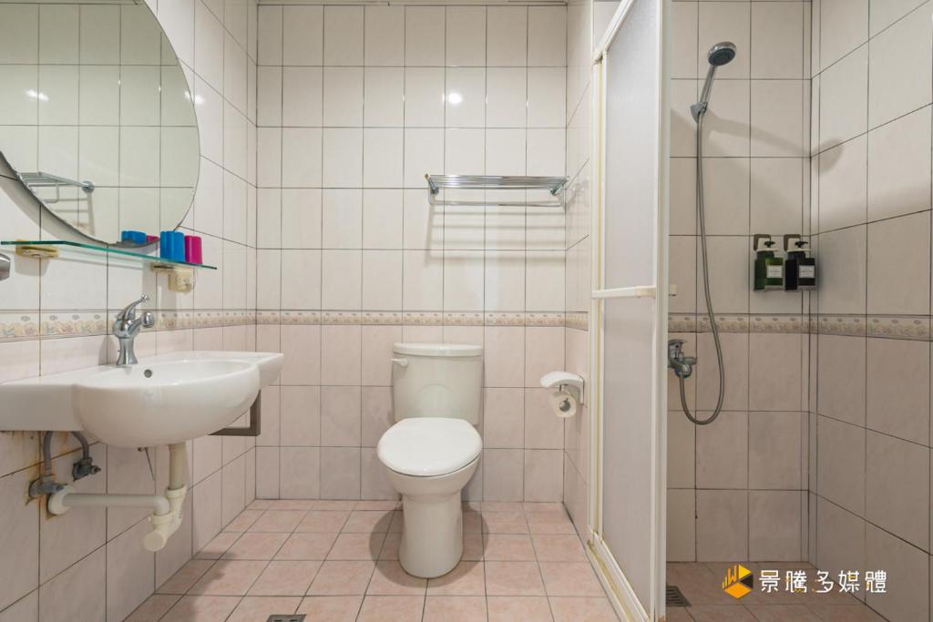 a bathroom with a toilet and a sink and a shower at Promised Land B&amp;B in Taitung City