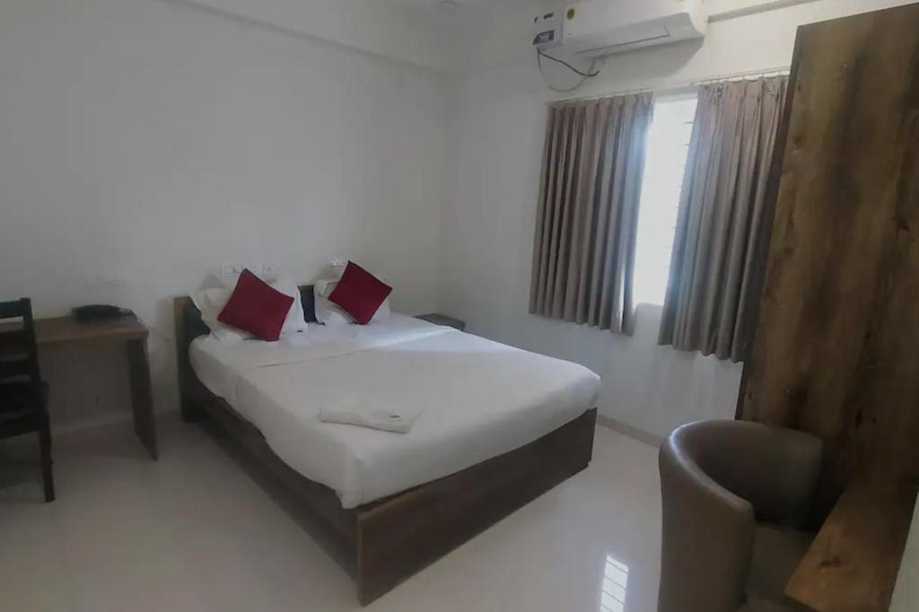 um quarto com uma cama, uma cadeira e uma janela em Brand New Suite Room em Bangalore