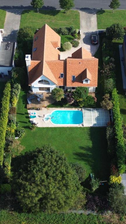 une vue aérienne d'une maison avec piscine dans l'établissement Chambre Hugues entre Caen et la mer avec piscine, à Mathieu