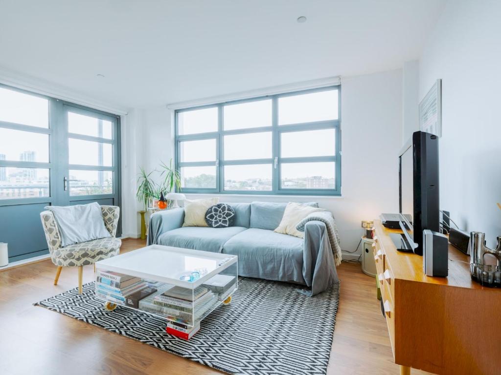 a living room with a couch and a tv at Pass the Keys Central Location Flat near Old St and Dalston Overlooking Rosemary Park and Regents Canal in London