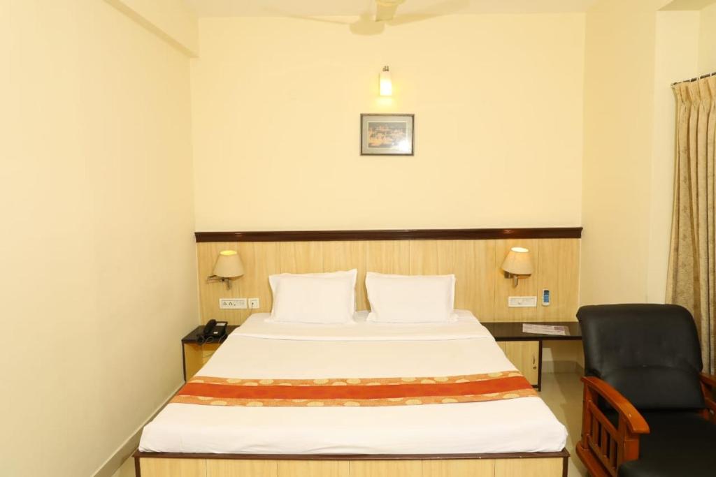Pokój hotelowy z łóżkiem i krzesłem w obiekcie Hotel Shrie Shaanth w mieście Selam