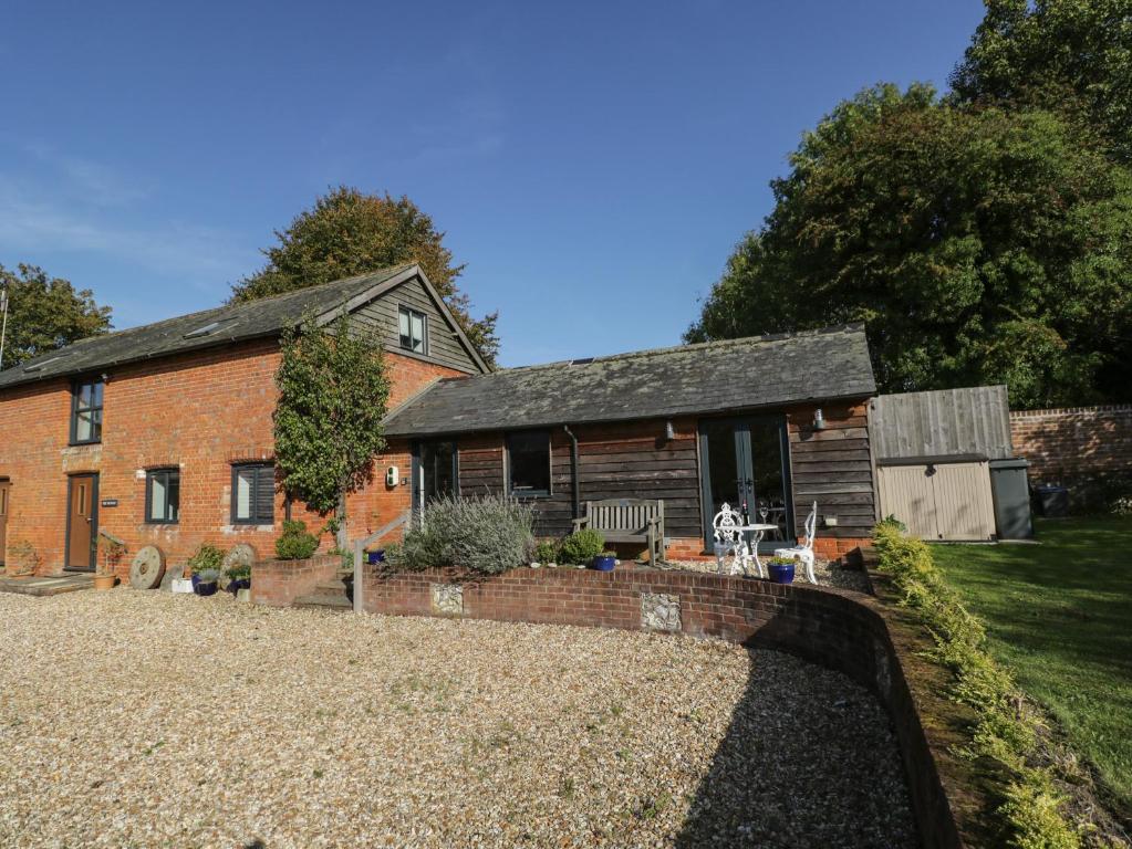 uma velha casa de tijolos com um quintal em frente em The DunnitManor Farm em Salisbury