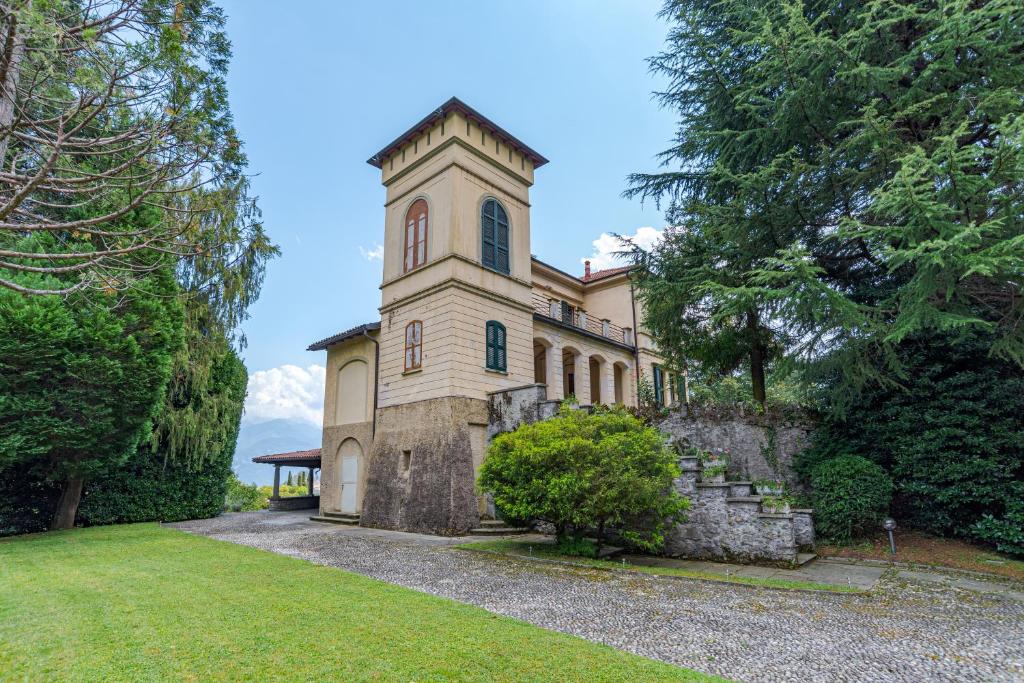 ein großes Gebäude mit einem Turm auf einem Hof in der Unterkunft Villa Harriet in Grandola ed Uniti