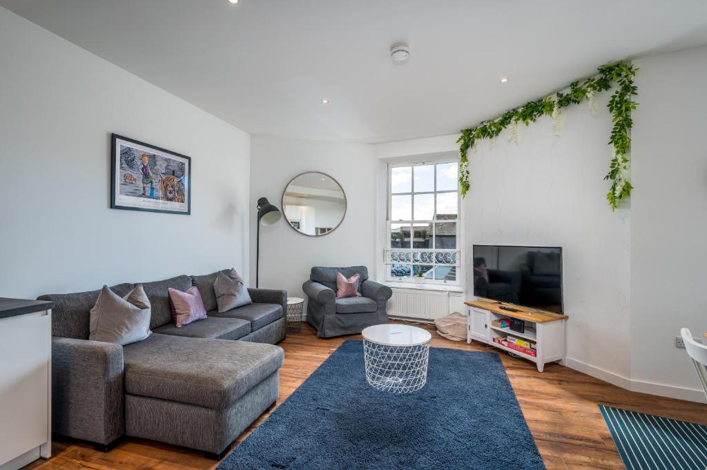 uma sala de estar com um sofá e uma televisão em Casa Fresa - Cowgate House em Dundee