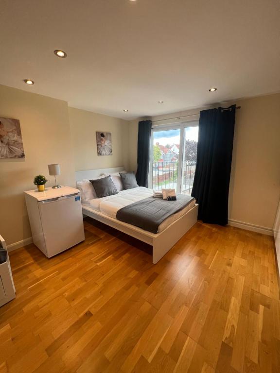a bedroom with a bed and a large window at Stunning House 15 min from Wembley arena in London