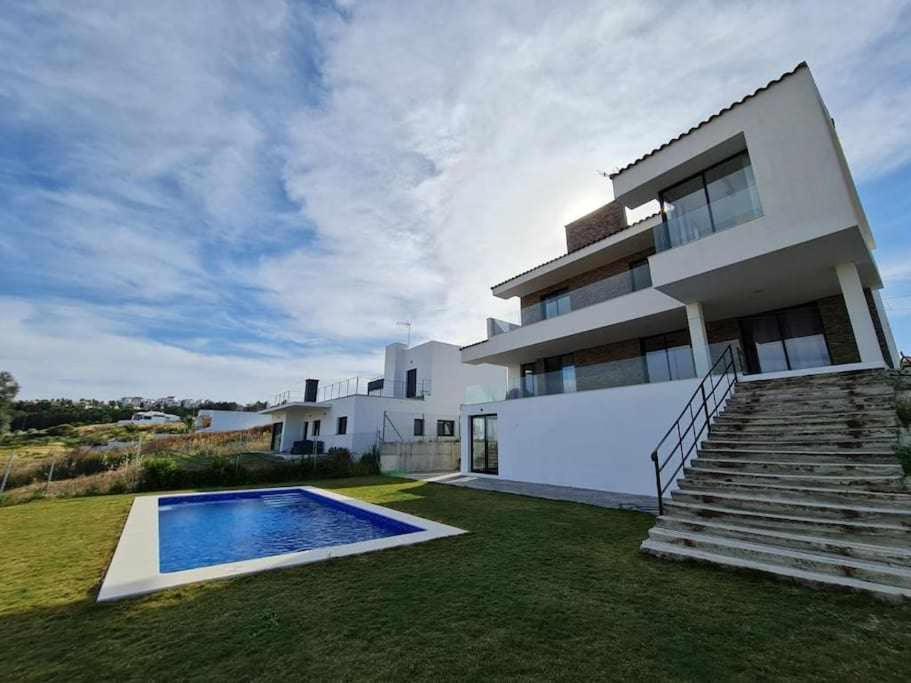 ein weißes Haus mit einem Pool im Hof in der Unterkunft Elcano Village Sanlucar Housing in Sanlúcar de Barrameda