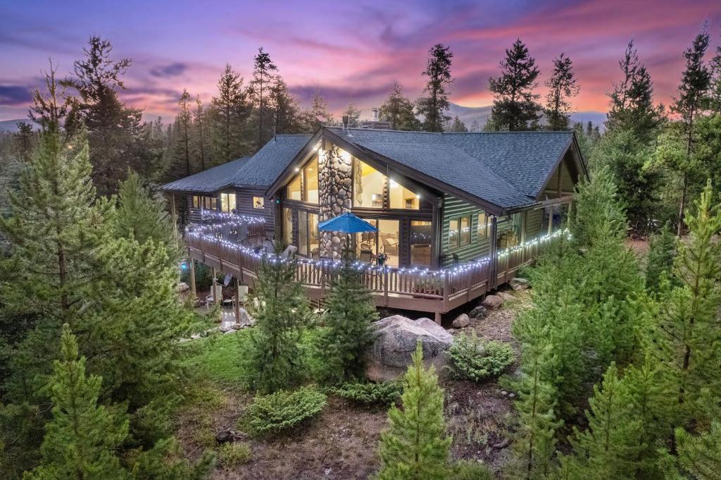 a house in the woods with lights on it at The Gemstone Grand by Leavetown Vacations in Grand Lake