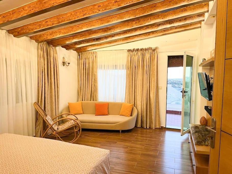 een woonkamer met een bank en een tv. bij Tranquila Vista - Villa au cœur de la nature in Tanger