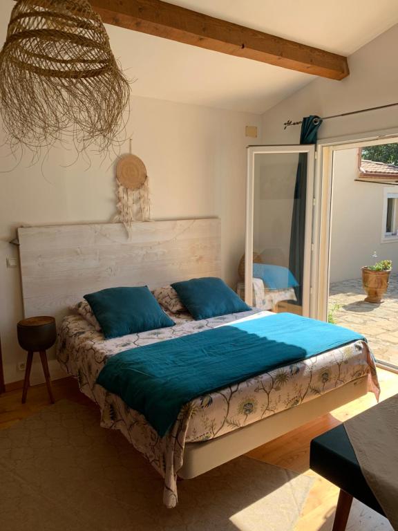 um quarto com uma cama com almofadas azuis em La chambre haute et son spa em Nîmes