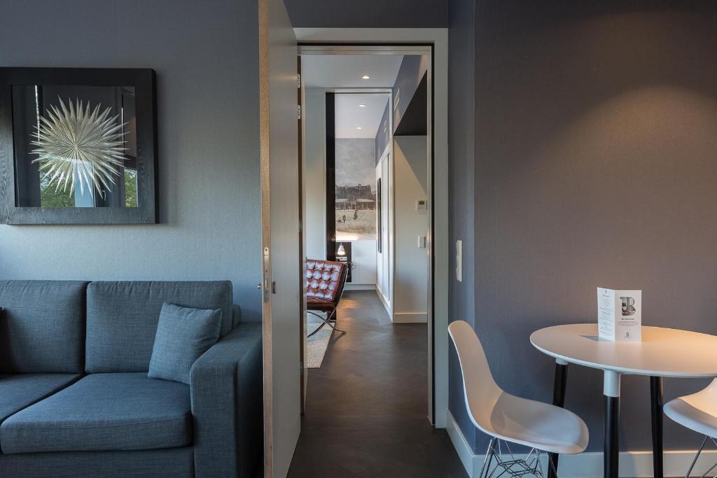 ein Wohnzimmer mit einem Sofa und einem Tisch in der Unterkunft B-aparthotel Kennedy in Den Haag
