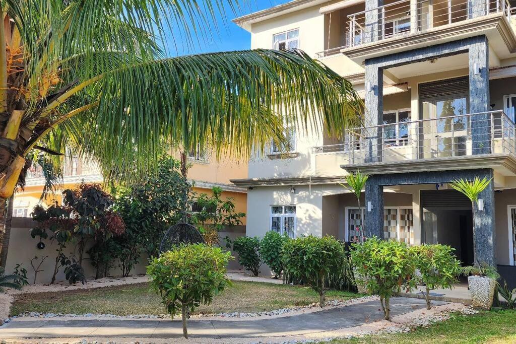 a building with a palm tree in front of it at Number 8, 2nd Floor, Pebble Bay Apartments in Grand Baie