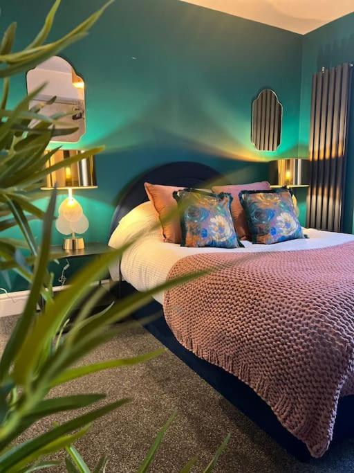 Un dormitorio con una cama con almohadas y una planta en Canalside Terrace-Boutique Stay Worcester City, en Worcester