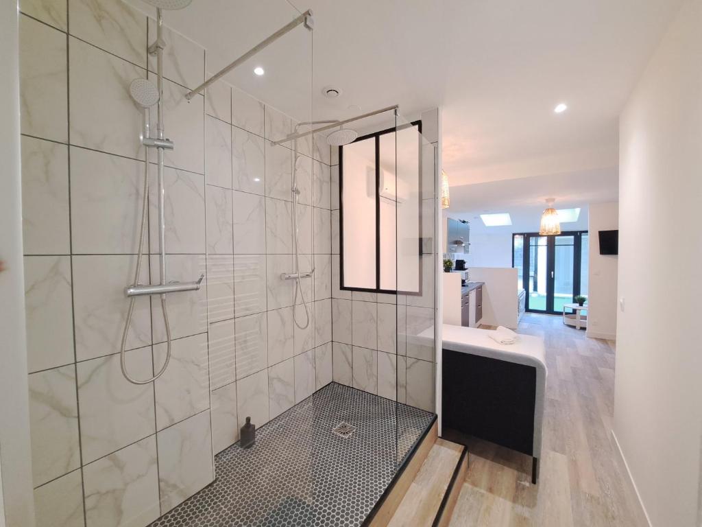 a large bathroom with a shower and a sink at Maputo - Appartement climatisé in Reims