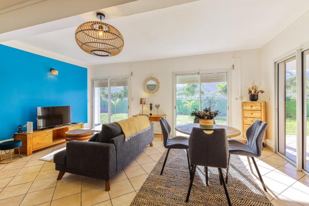 a living room with a couch and chairs and a table at Kaz Voyageur in Saint-Paul