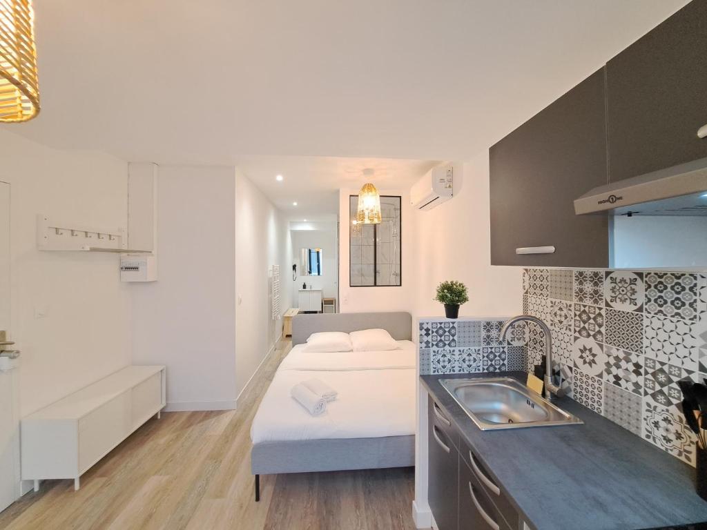 a kitchen with a bed and a sink in a room at Maputo - Appartement climatisé in Reims