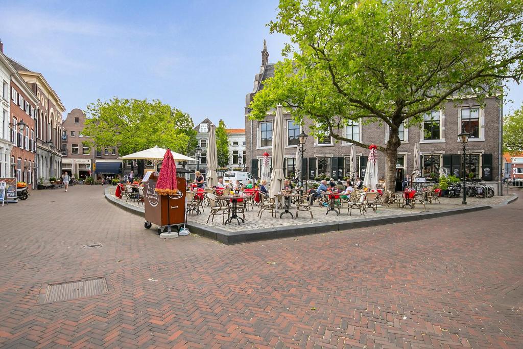 eine Gruppe von Tischen und Stühlen in einer Stadtstraße in der Unterkunft Tourist Travel Inn in Schiedam