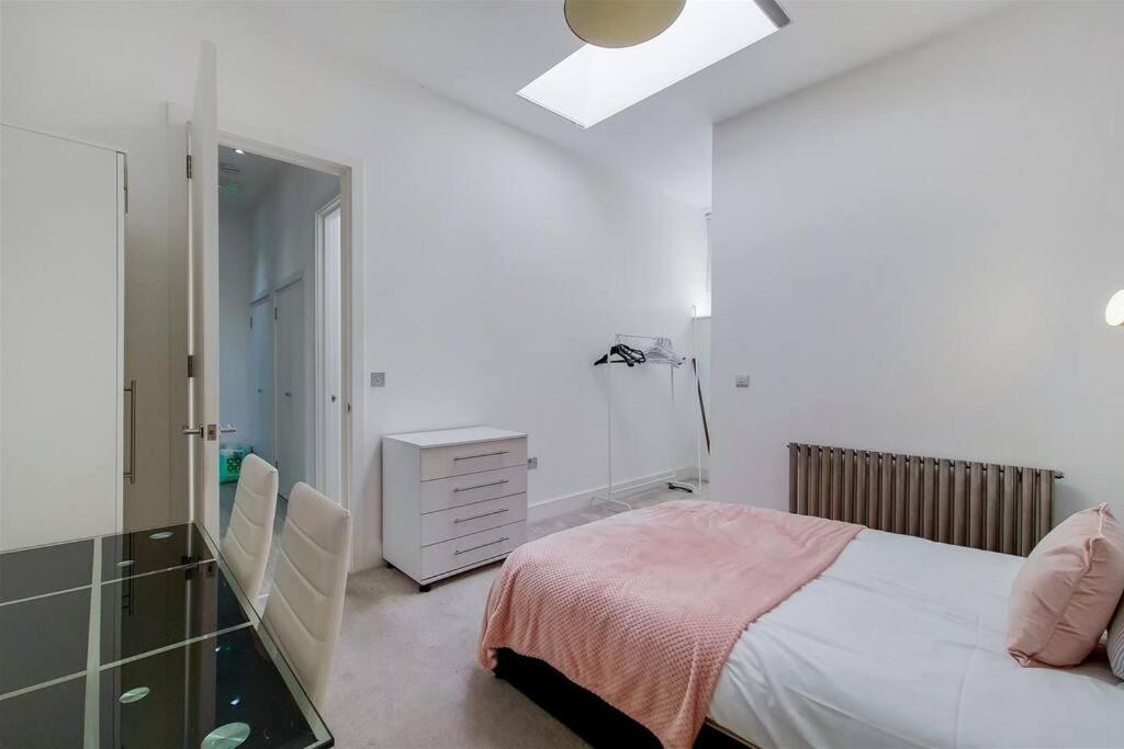 a bedroom with a bed and a dresser and a mirror at Luxurious 4 Bedroom Entire Flat in King's Cross in London