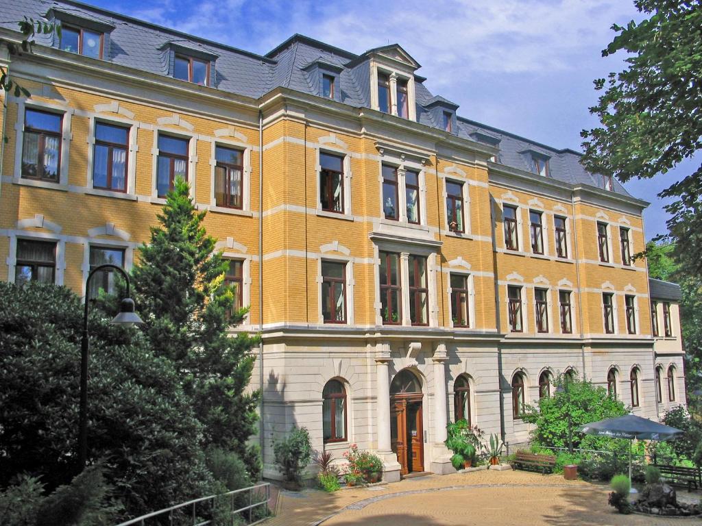 アウエにあるSächsisches Gemeinschafts-Diakonissenhaus ZION e. V.の目の前に木が立つ大きな黄色の建物