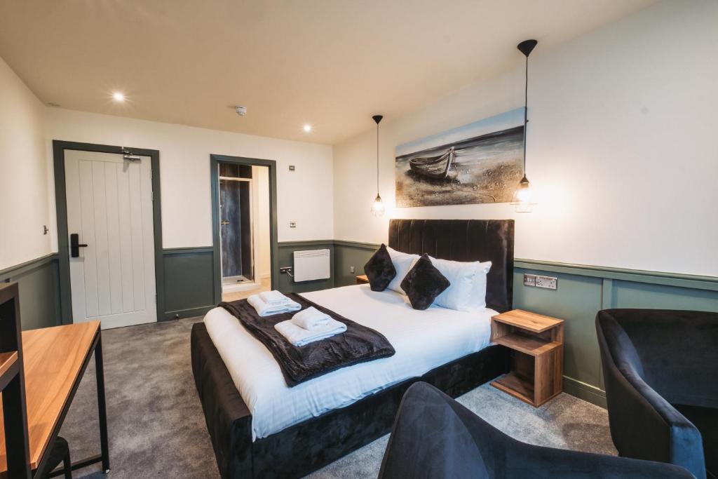 Un dormitorio con una cama, un sofá y una silla. en The Royal Bar &amp; Shaker, en Morecambe