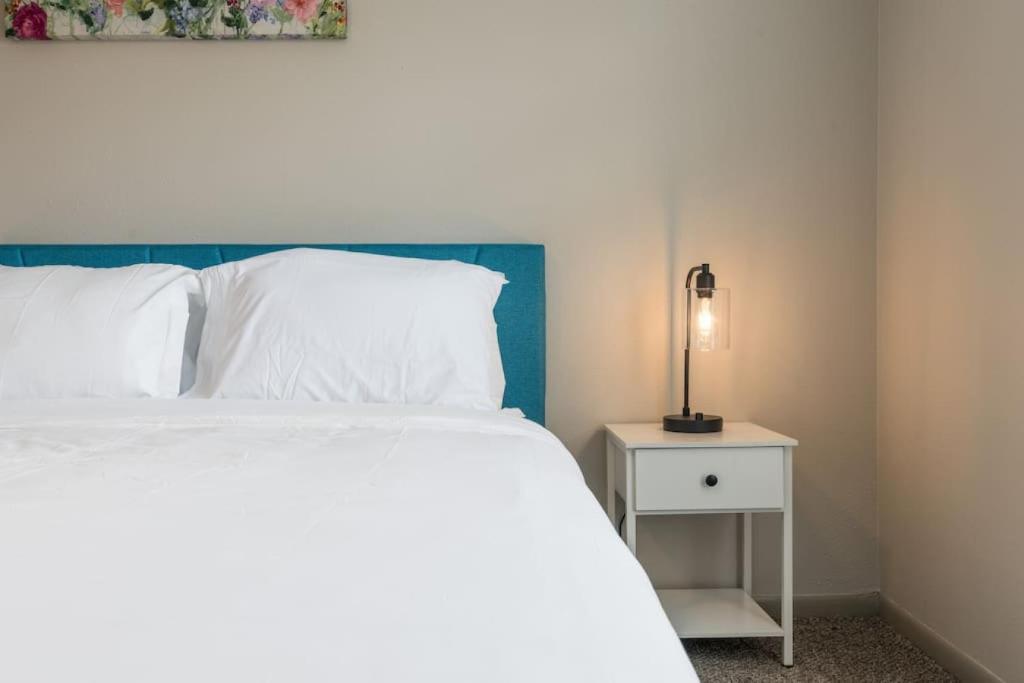 ein Schlafzimmer mit einem weißen Bett und einer Lampe auf einem Nachttisch in der Unterkunft Affordable 2-Bed Fishers in Fishers