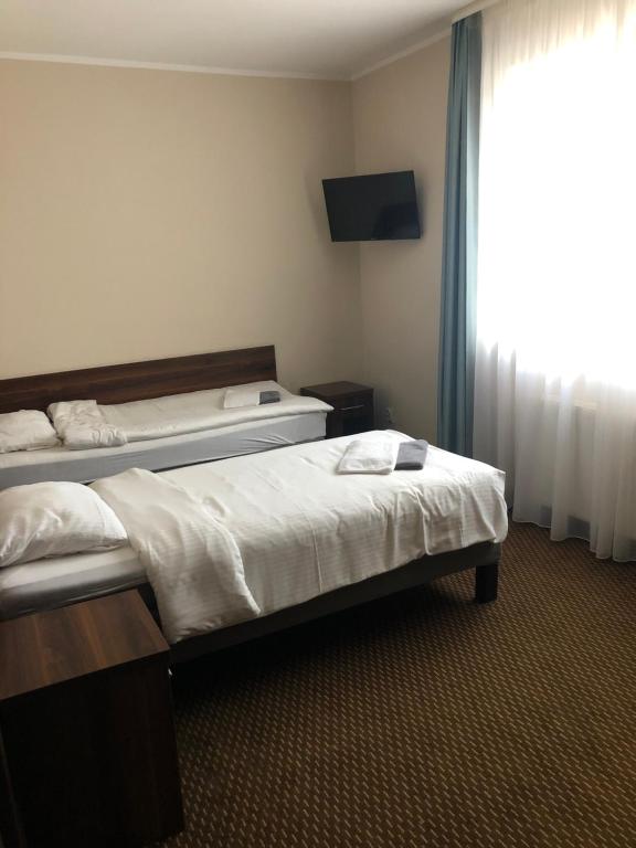 ein Hotelzimmer mit 2 Betten und einem Fenster in der Unterkunft Świdnica Kolonia noclegi in Świdnica